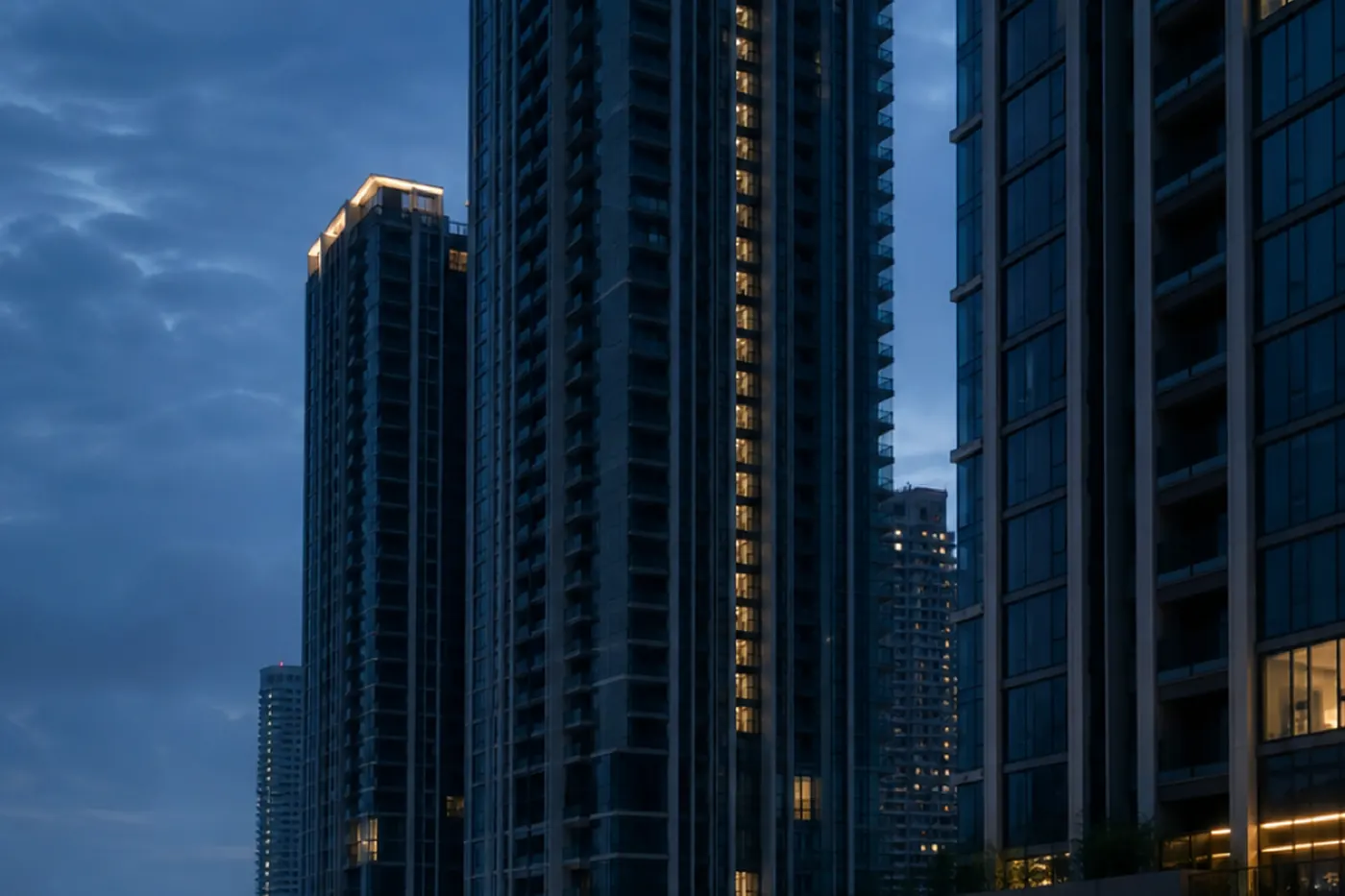 Unlit high-rise condominium towers at dusk in Bangkok