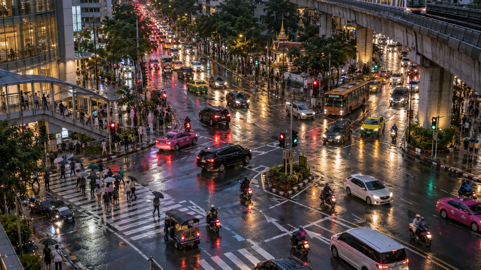 A rain-soaked Bangkok junction at dusk seen from above, buses, taxis and motorcycles converging beneath an elevated road