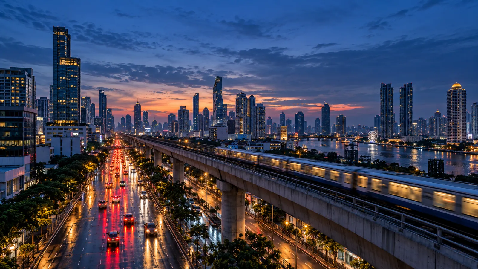 Bangkok at dusk from above, tail lights streaming along an avenue beside the elevated railway, the river and towers beyond