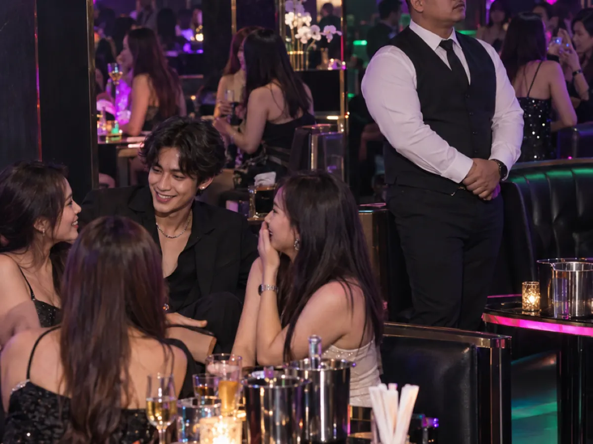 A host entertains a table while a doorman stands by